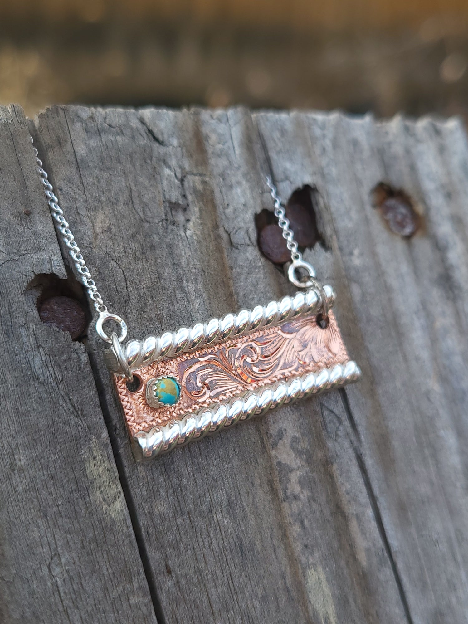 Copper and silver bar necklace on a wooden surface