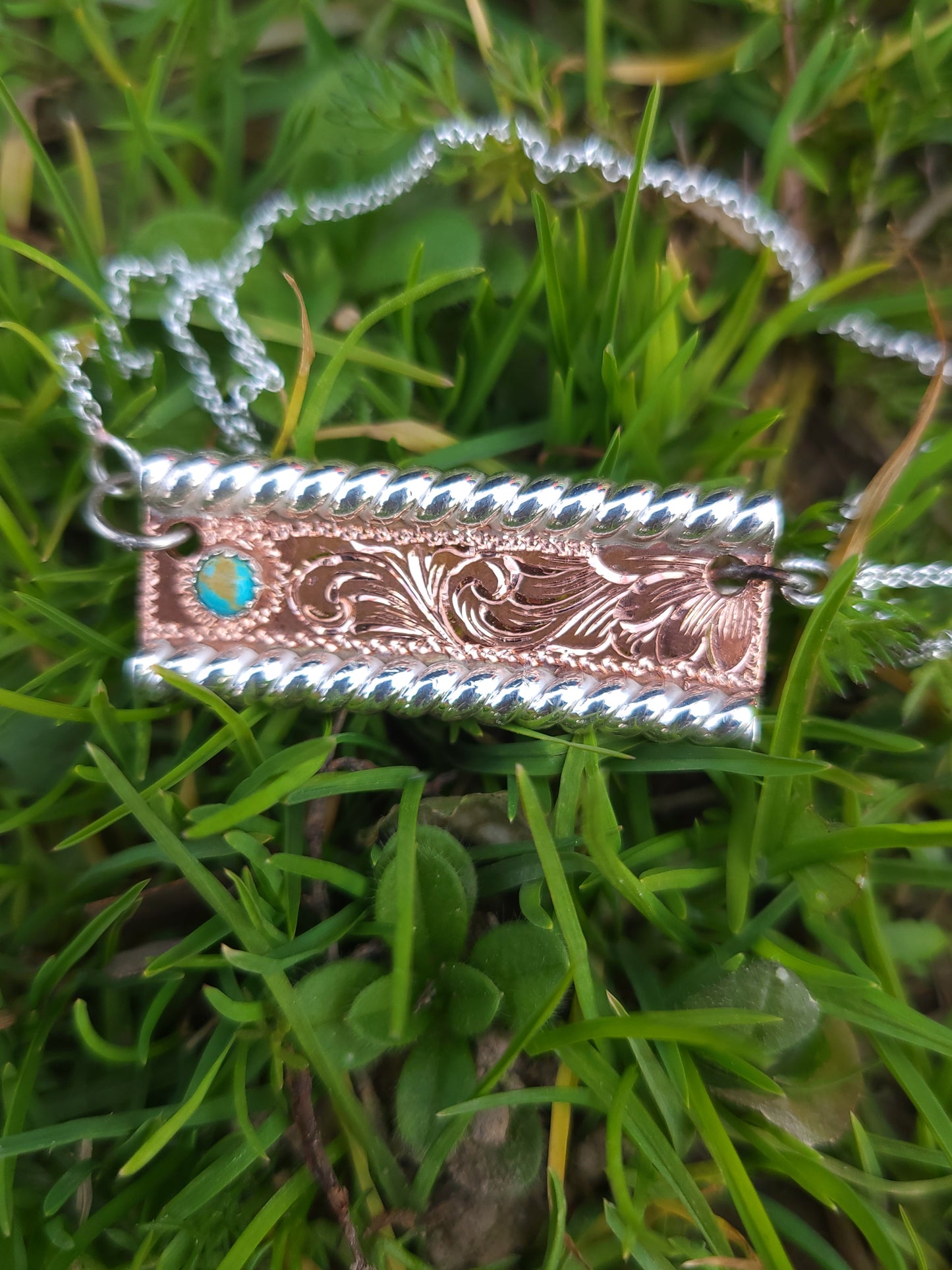 Decorative pendant necklace on grass