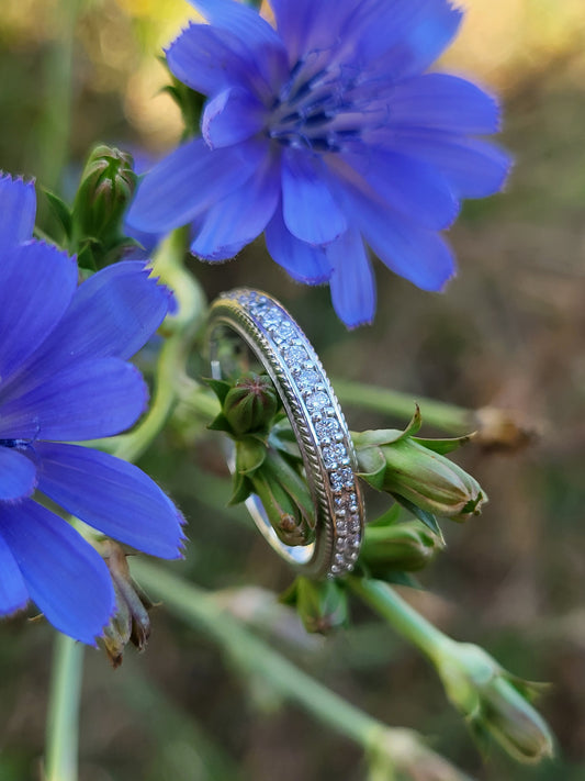 Diamond ring with rope detail on a blue flower with a blurred natural background