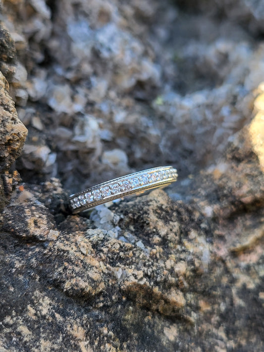Ring with diamonds and rope detail on a textured stone surface